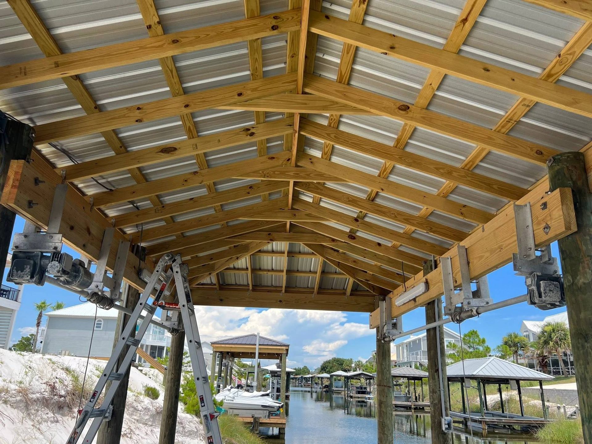 Wiring run through the roof trusses of a covered boat dock overlooking the canal