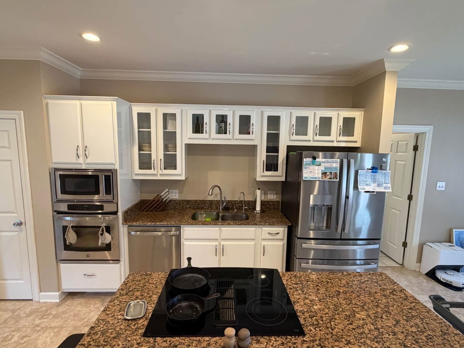Existing kitchen before the lighting upgrade — white cabinets and granite counters with no cabinet lighting